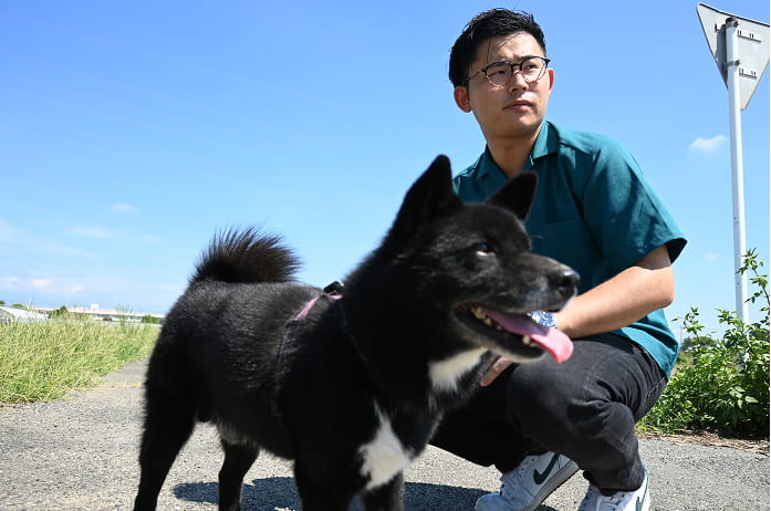 黒い愛犬を撫でる男性
